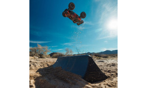 Arrma 1/16 Mini Kraton 3S DSC 4X4 RTR in black and red livery airborne off a sand ramp with dust trail and rugged off-road tyres