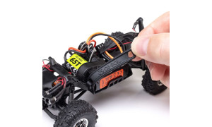 Close-up of Axial SCX30 RC truck internals showing motor, ESC, wiring, and suspension components